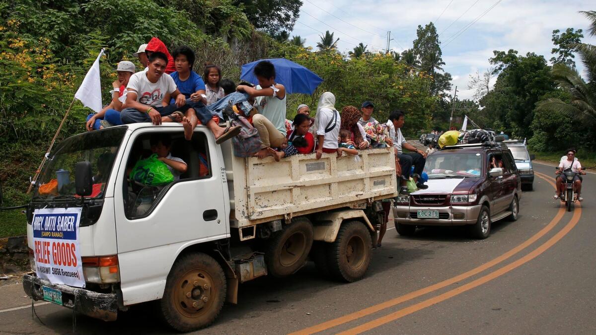 Displaced residents continue to flee via convoy to safer areas as government troops battle with Muslim militants Monday, May 29, 2017, in Marawi, southern Philippines.