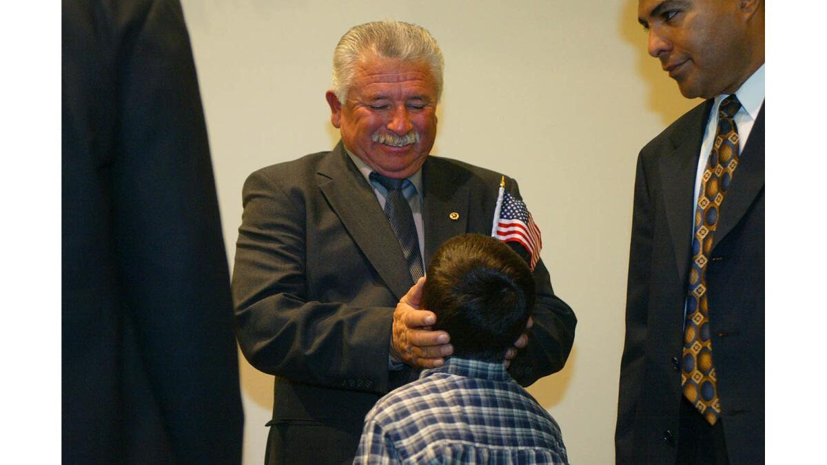 Nov. 7, 2002: David Gonzales Jr. greets grandson Ian Gonzales at the ceremony. California State Assmblyman Tony Cardenas is at right.