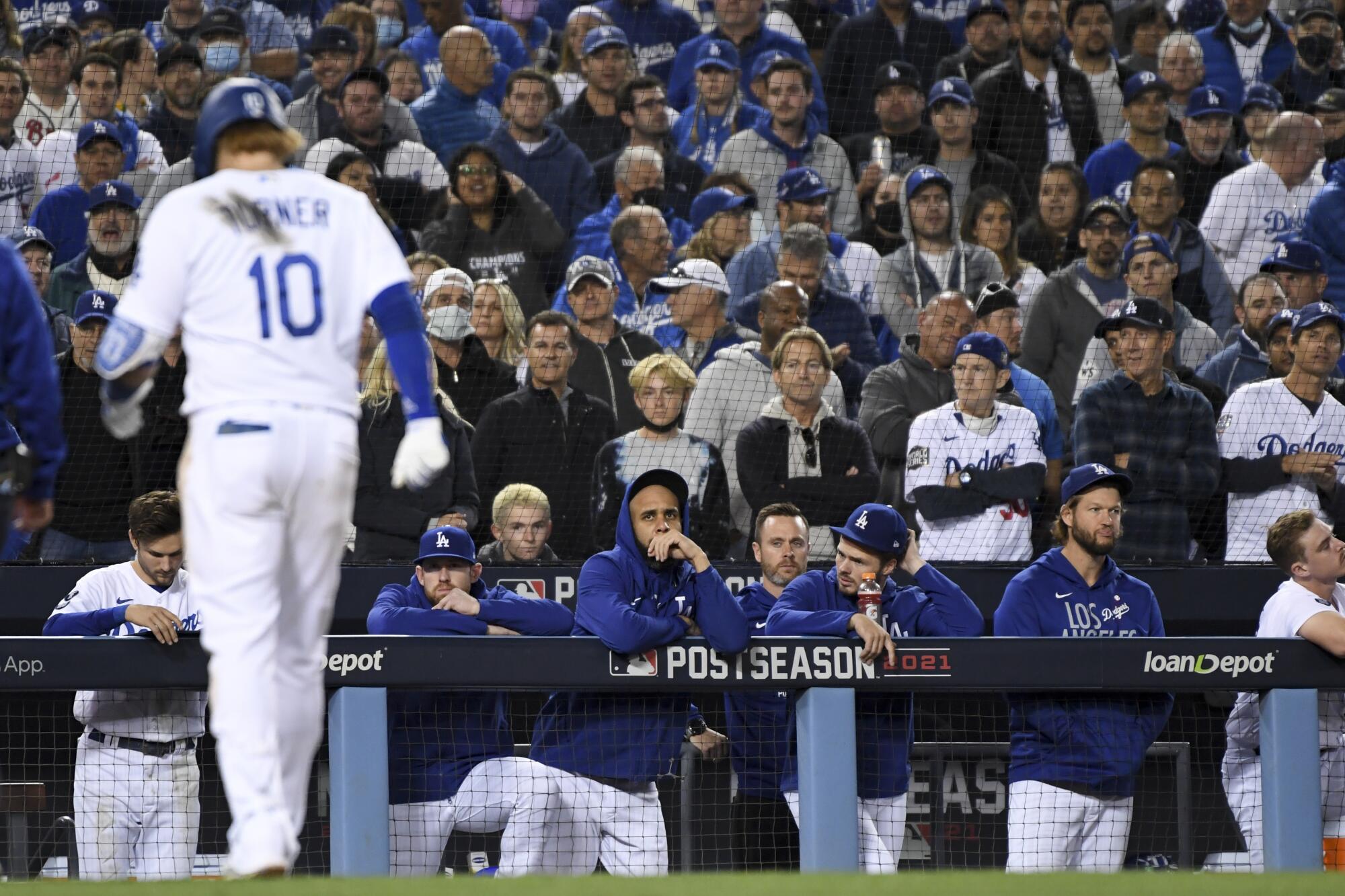 Dodgers players watch teammate Justin Turner limp off the field during the seventh inning.