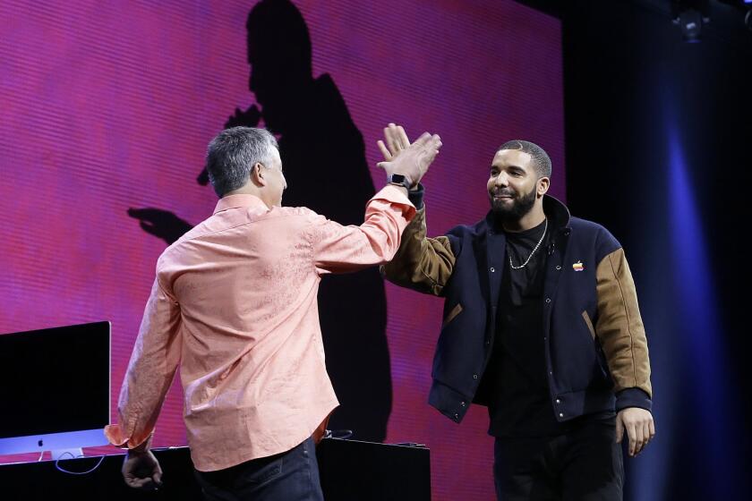 Musician Drake, right, high fives Eddy Cue, Apple senior vice president of Internet Software and Services, during the Apple Worldwide Developers Conference in San Francisco.