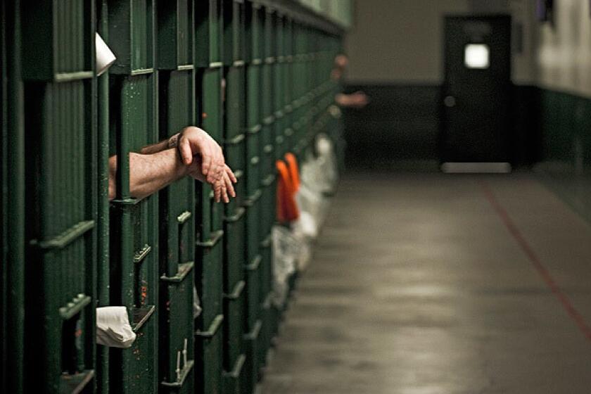 An inmates hands stick out of his cell at Men's Central Jail in November 2011.