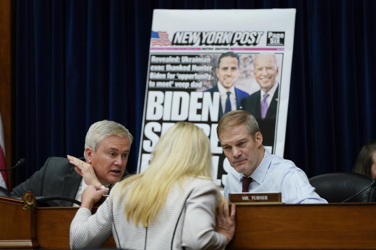 James Comer and Jim Jordan talk with Marjorie Taylor Greene during a committee hearing