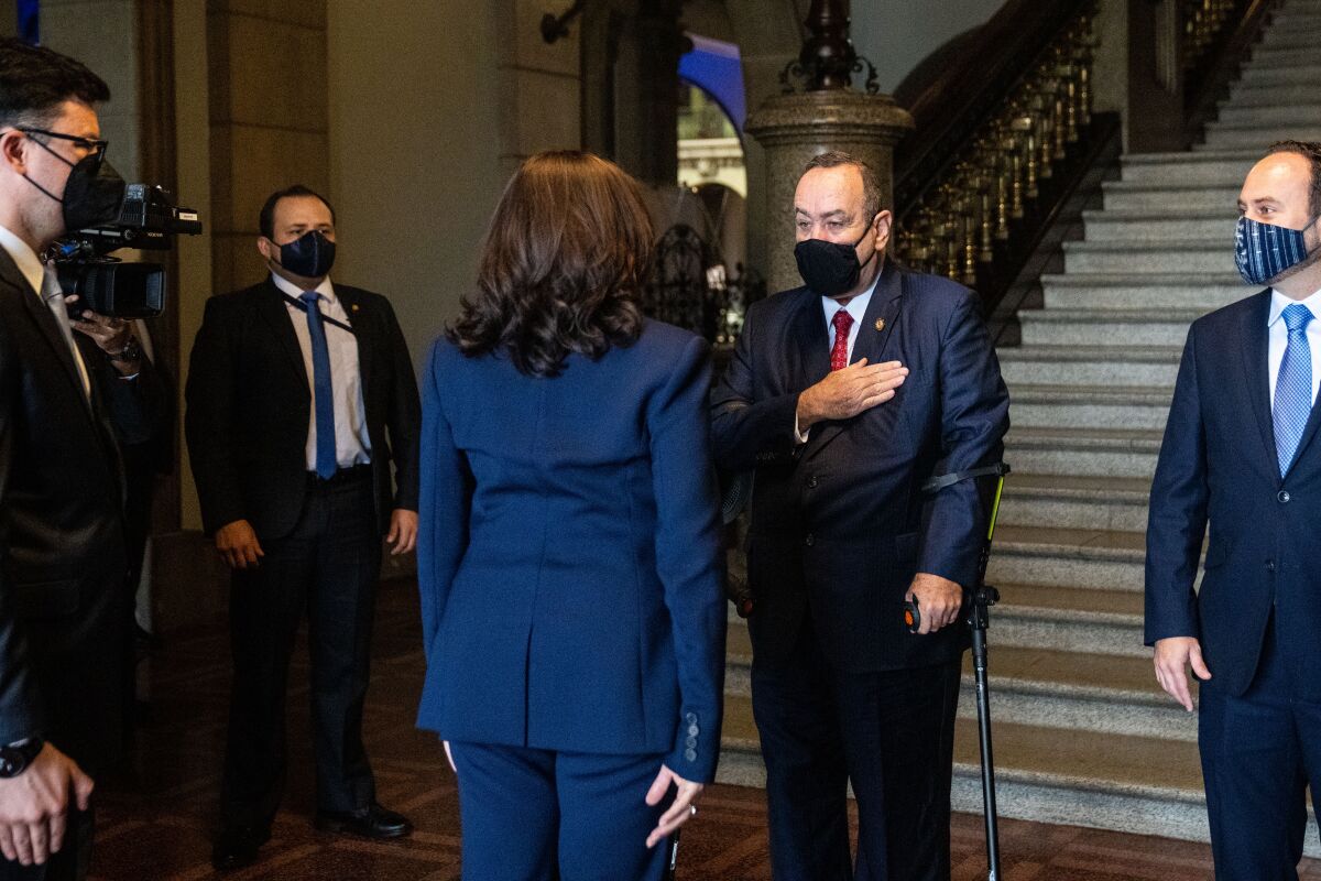 Guatemalan President Alejandro Giammattei greets Vice President Kamala Harris while three men look on