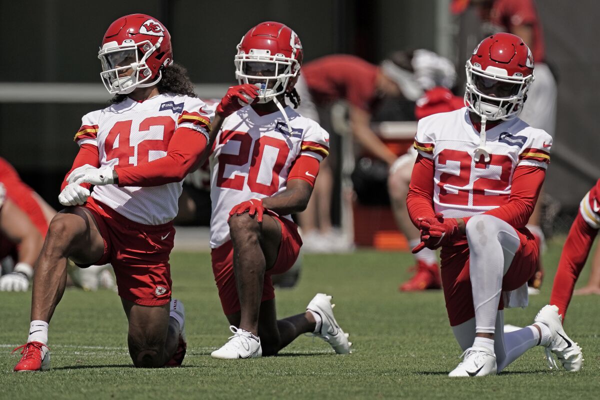 Kansas City Chiefs defensive back Devon Key (42), safety Justin Reid (20) and safety Juan Thornhill (22) stretch during the NFL football team's organized team activities Thursday, June 9, 2022, in Kansas City, Mo. (AP Photo/Charlie Riedel)