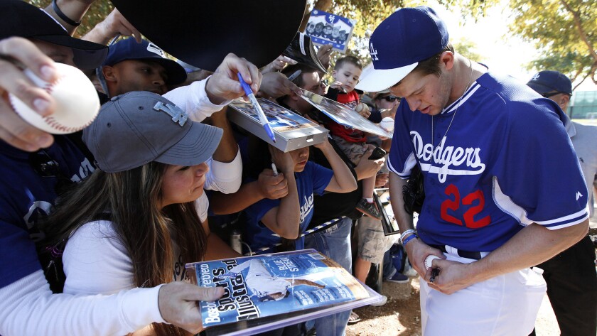 Dodgers starter Clayton Kershaw signs autographs for fans at the team's spring training practice facility in Phoenix in February.