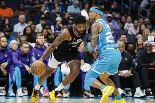 Los Angeles Clippers forward Paul George, left, drives into Charlotte Hornets guard Tre Mann.