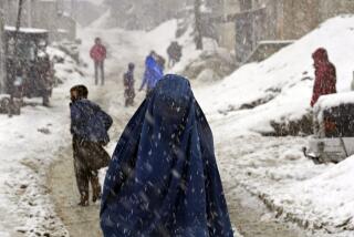 People navigate a snow covered street on a hilltop in Kabul, Afghanistan, Tuesday, Feb. 22, 2022. (AP Photo/Hussein Malla)
