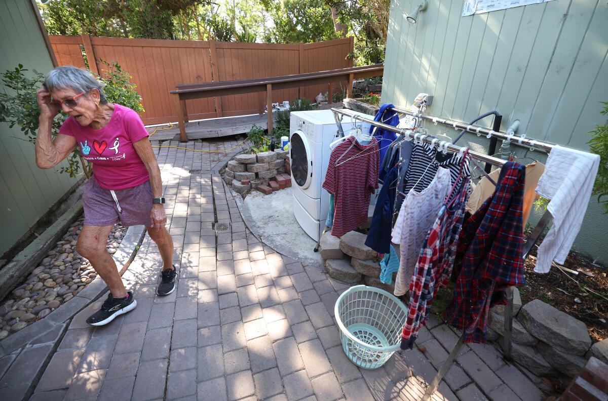 Sallie Reeves outside with a washing machine and clothes on hangers