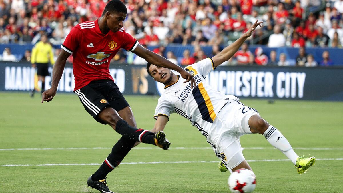 Manchester United's Marcus Rashford unleashes a shot in front of Galaxy defender Hugo Arellano for his second goal of the game Saturday night at StubHub Center.