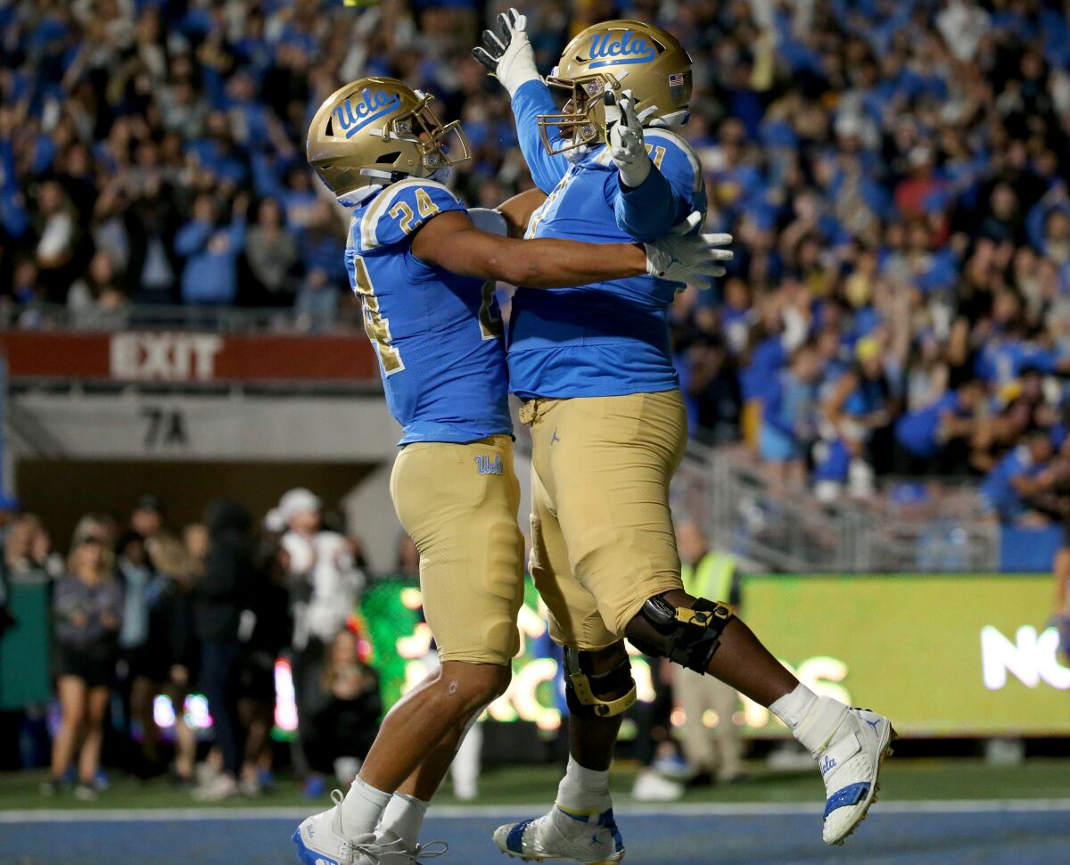 UCLA running back Zach Charbonnet, left, celebrates with offensive lineman Raiqwon O'Neal.