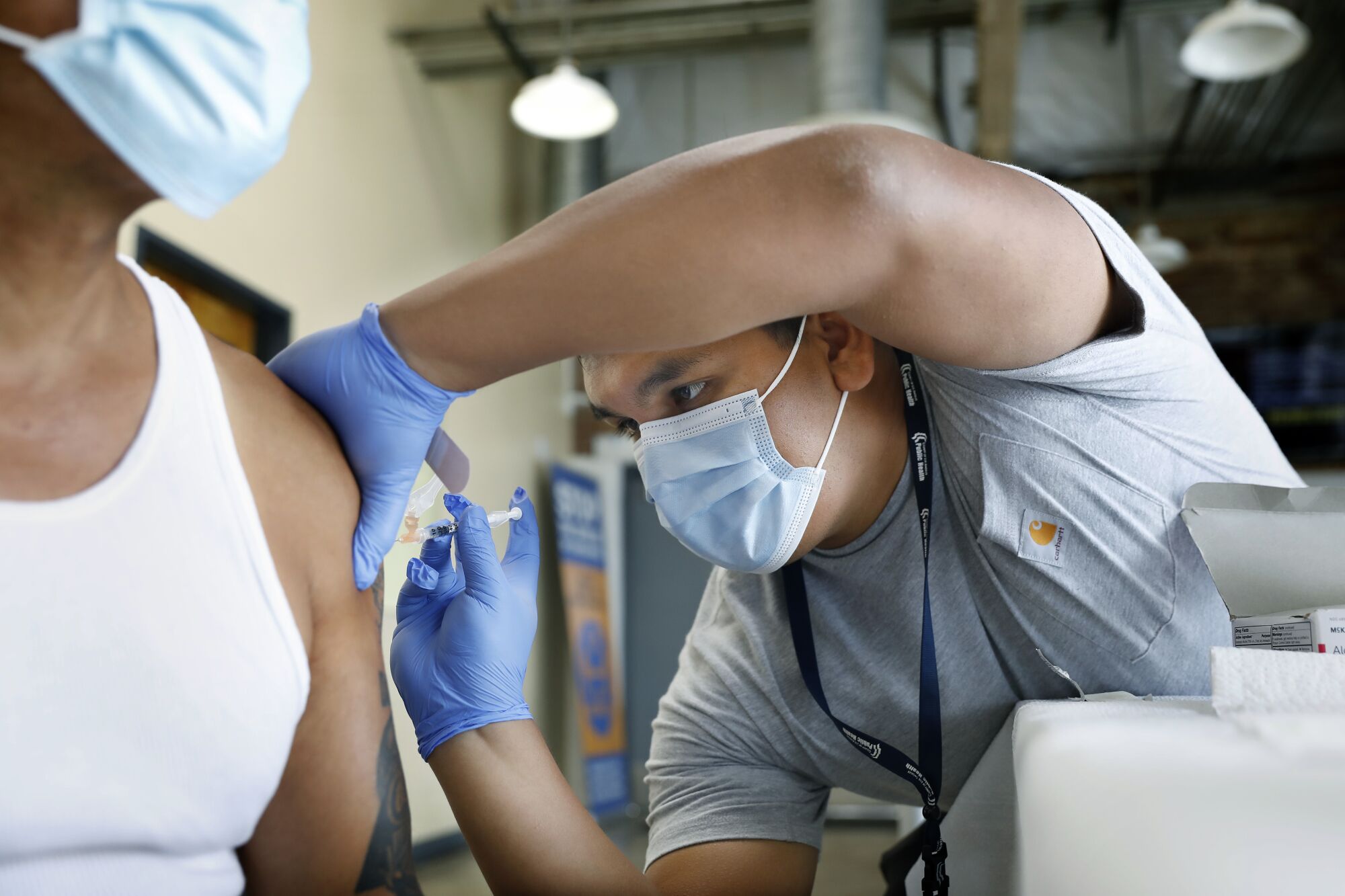 A nurse administers a COVID-19 vaccine into a patient's arm.