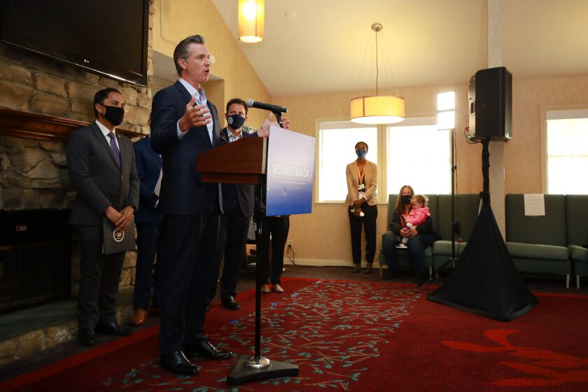 SAN DIEGO, CA - MAY 11: Governor Gavin Newsom speaks at a news conference about a $12 billion package bolstering the state's response to the homelessness crisis at the Kearney Vista Apartments, which houses homeless people in a converted hotel on Tuesday, May 11, 2021 in San Diego, CA. San Diego Mayor Todd Gloria, left, looks on. (K.C. Alfred / The San Diego Union-Tribune)