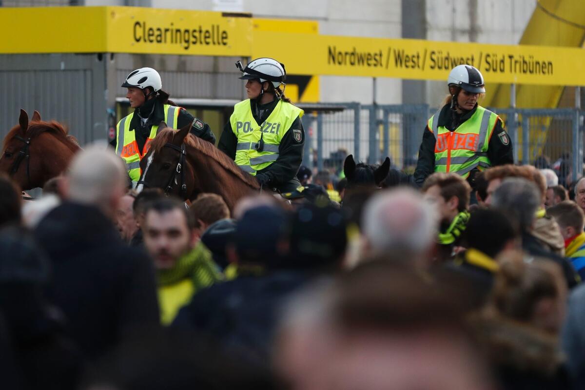 Police patrol on horseback Tuesday outside the stadium in Dortmund, Germany, after reports of explosions.