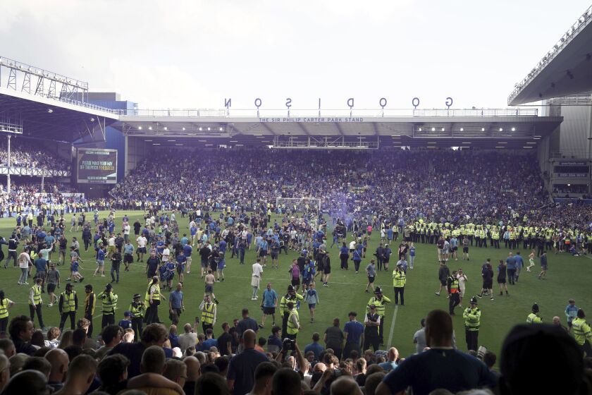 Everton fans invade the pitch after securing their safety in the English Premier League at Goodison Park, Liverpool, England, Sunday May 28, 2023. (Peter Byrne/PA via AP)