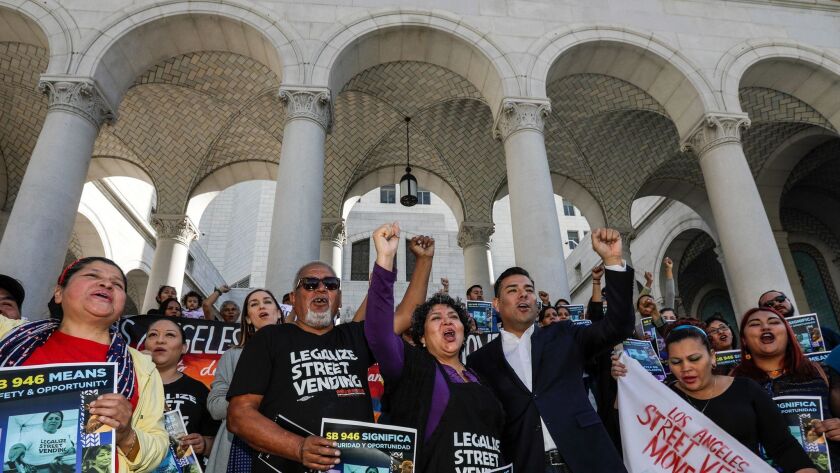 Sidewalk vendors rally on the steps of Los Angeles City Hall on Friday in support of Senate Bill 946, introduced by state Sen. Ricardo Lara (D-Bell Gardens), third from right.