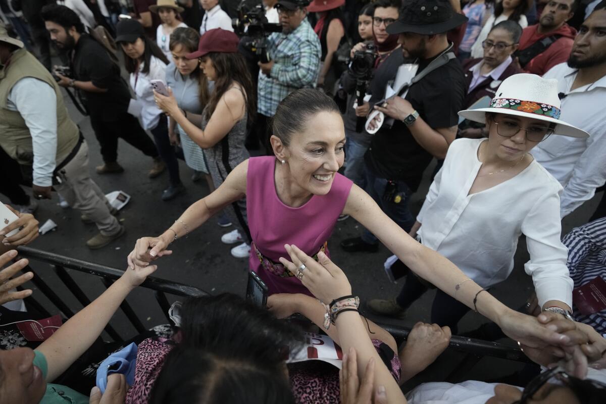 A woman greets supporters and holds their hands.