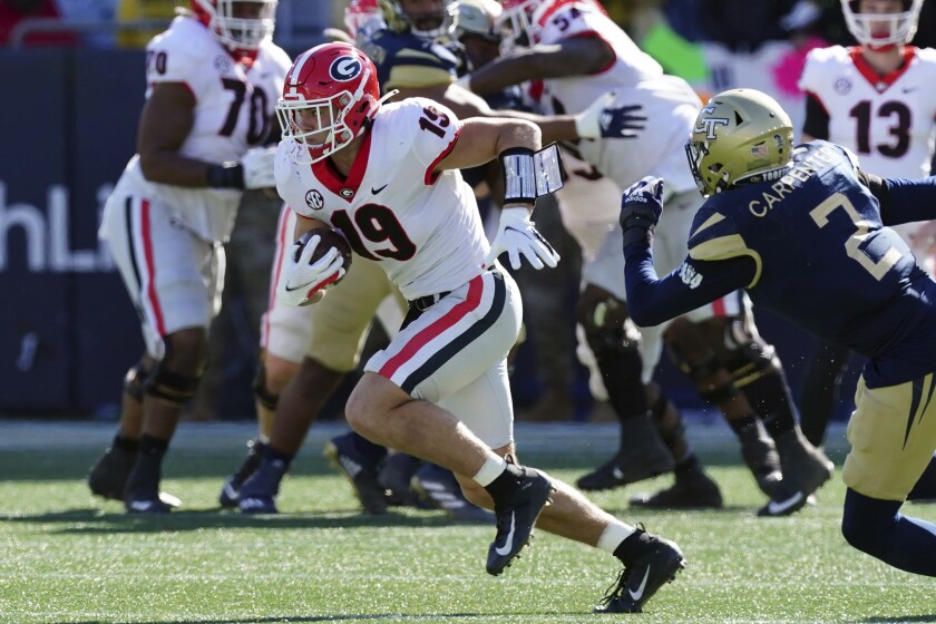 Georgia tight end Brock Bowers (19) runs for a touchdown after a catch as Georgia Tech defensive back Tariq Carpenter (2) gives chase in the first half of an NCAA college football game Saturday, Nov. 27, 2021, in Atlanta. (AP Photo/John Bazemore)