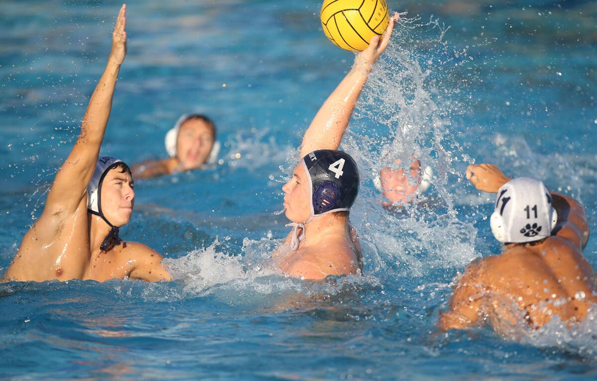 Newport Harbor's Eli Liechty (4) throws the ball between two Loyola defenders during a CIF Southern California Regional Division I semifinal match at Segerstrom High on Saturday.
