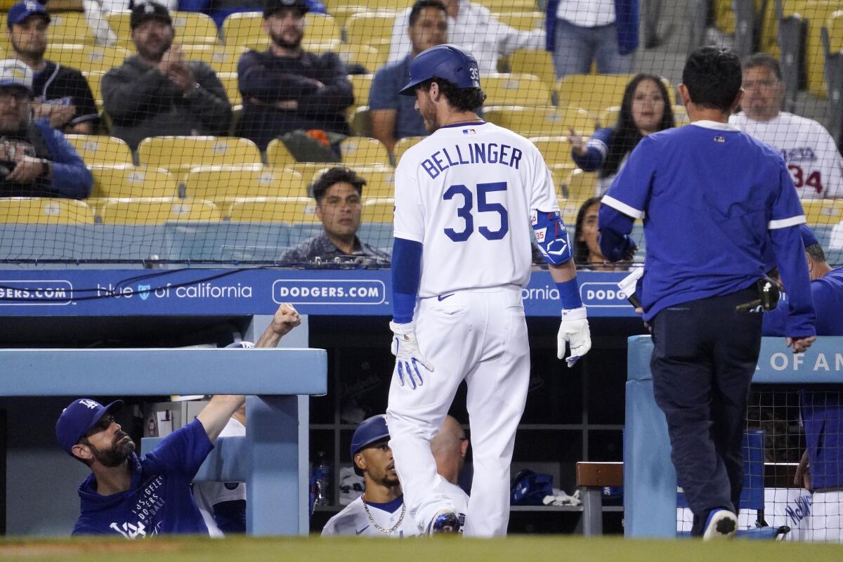 The Dodgers' Cody Bellinger holds the back of his leg after being taken out of the game in the fifth inning June 11, 2021.