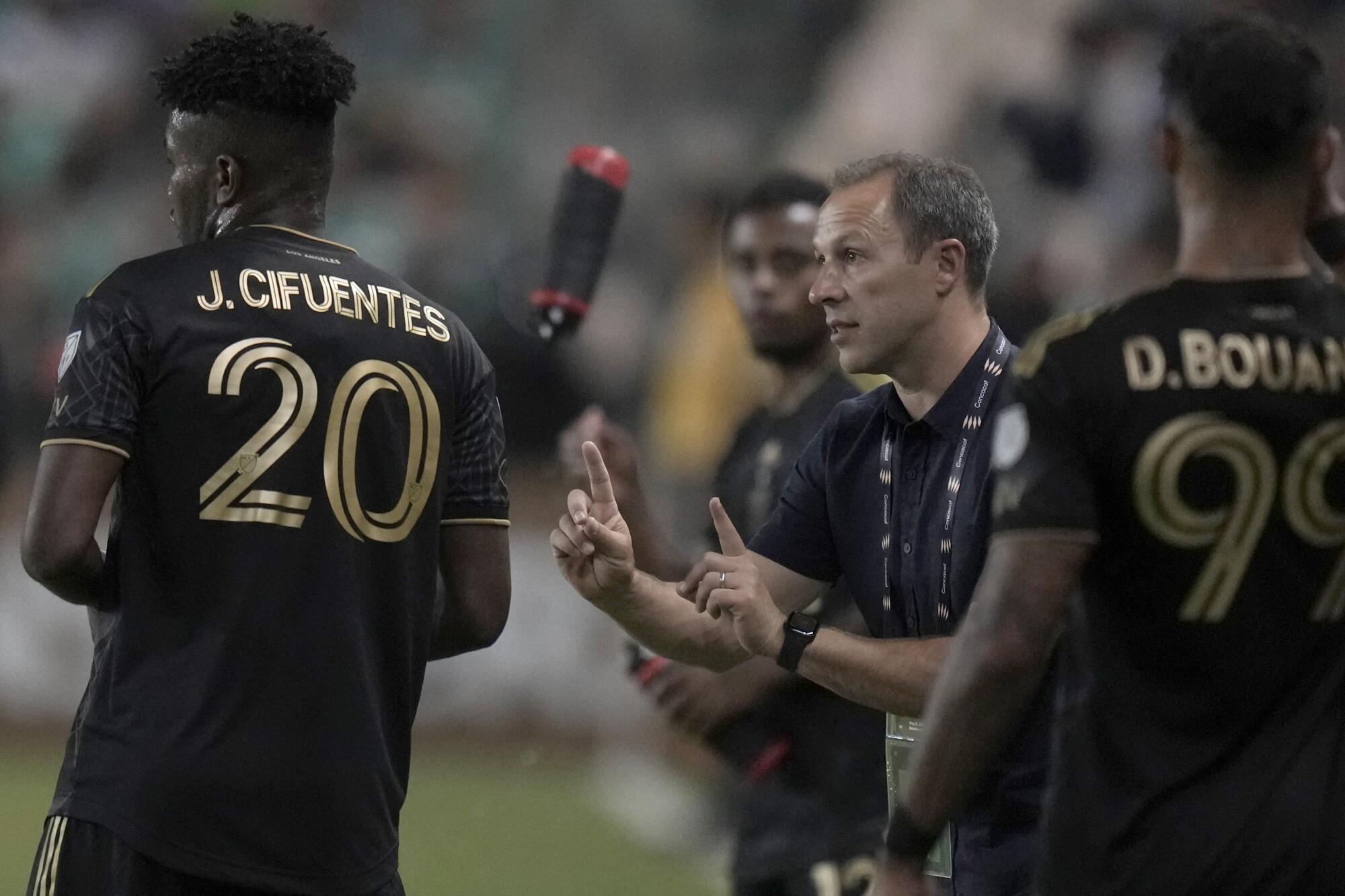 LAFC coach Steve Cherundolo talks with José Cifuentes on the sideline during a match