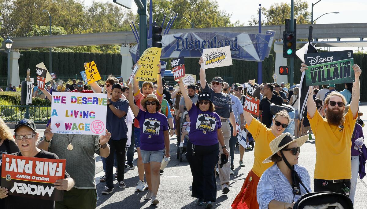 A crowd of demonstrators picketing underneath the main entrance to Disneyland