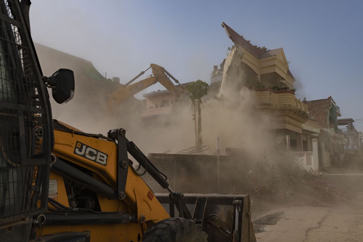 FILE- Authorities demolish the residence of activist Javed Ahmad they say has been constructed illegally in Prayagraj, India, Sunday, June 12, 2022. Protests have been erupting in many Indian cities to condemn the demolition of homes and businesses belonging to Muslims, in what critics call a growing pattern of “bulldozer justice” aimed at punishing activists from the minority group. Authorities said Ahmad was connected to Muslim religious protests that turned violent last Friday, sparked by derogatory remarks about Islam and the Prophet Muhammed. (AP Photo/Rajesh Kumar Singh, File)