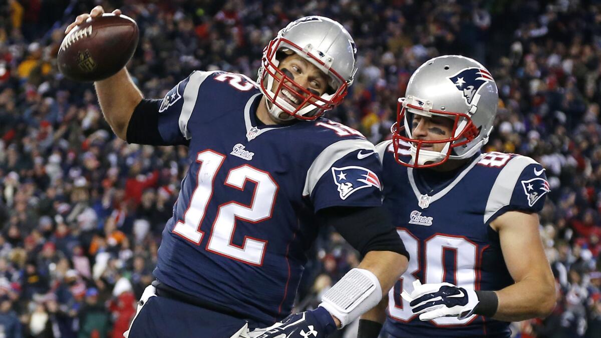 New England Patriots quarterback Tom Brady, left, celebrates with wide receiver Danny Amendola during the first half of a 43-21 win over the Denver Broncos on Sunday.