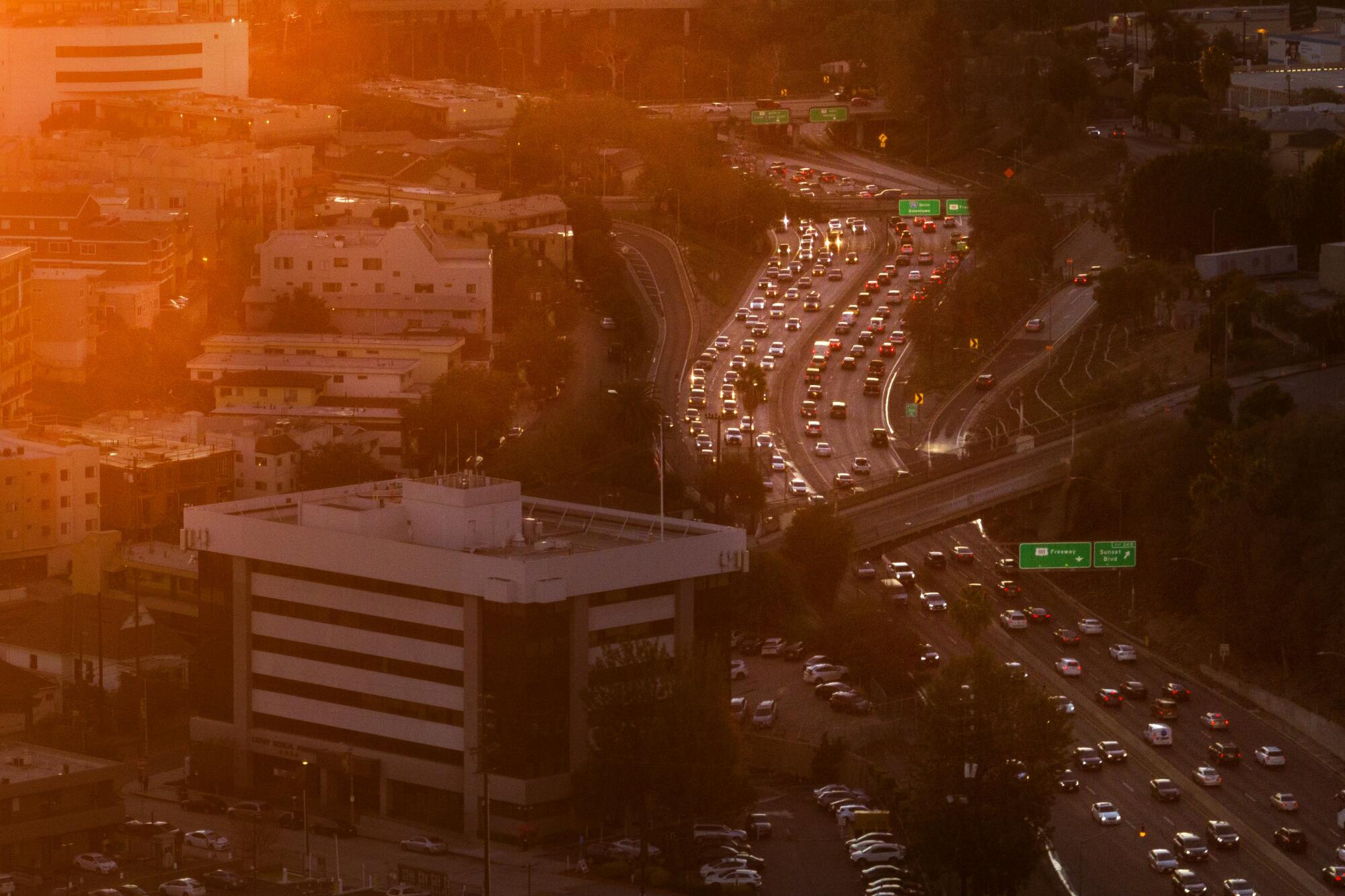 A red-toned sunset view of traffic on the 110 Freeway near Chinatown