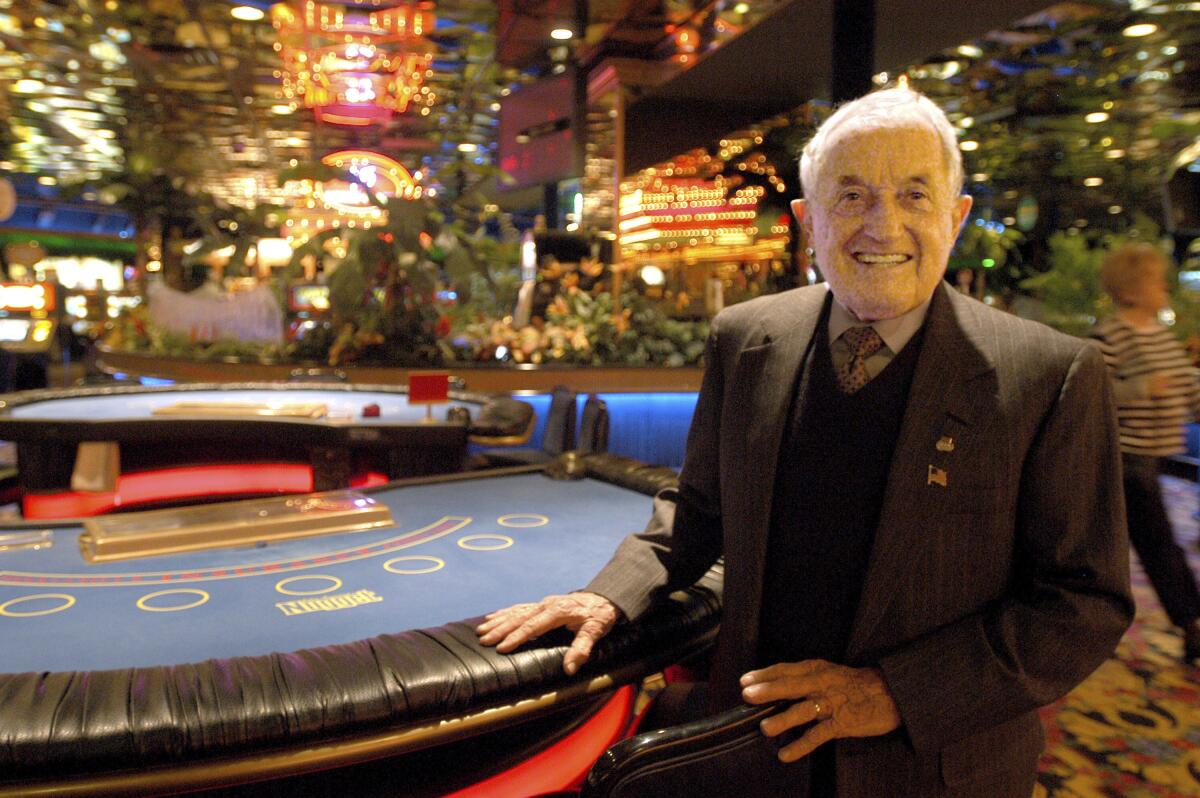 John Ascuaga sits at a casino card table.