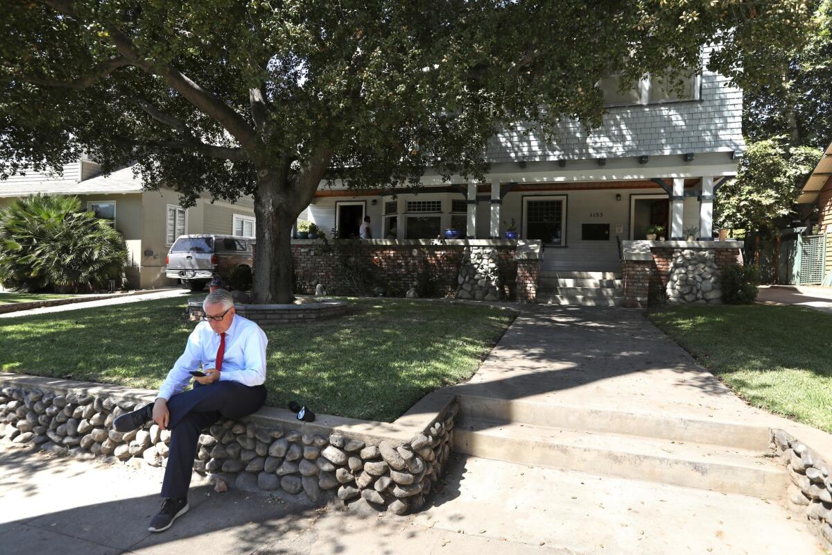 A reporter sits in front of the home where Vanessa Marquez was shot and killed by South Pasadena police Aug. 31, 2018.
