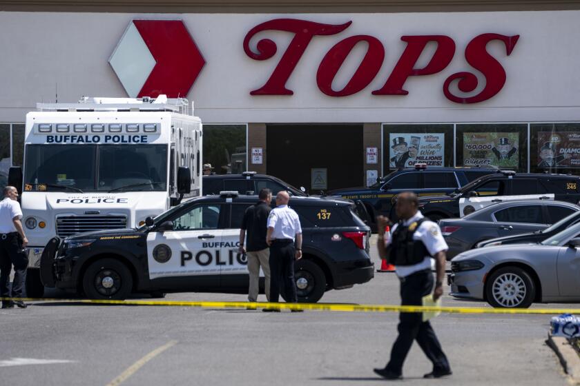 BUFFALO, NY - MAY 15: Law enforcement officials are seen at the scene of a mass shooting at Tops Friendly Market at Jefferson Avenue and Riley Street on Sunday, May 15, 2022 in Buffalo, NY. The fatal shooting of 10 people at a grocery store in a historically Black neighborhood of Buffalo by a young white gunman is being investigated as a hate crime and an act of "racially motivated violent extremism," according to federal officials. (Kent Nishimura / Los Angeles Times)