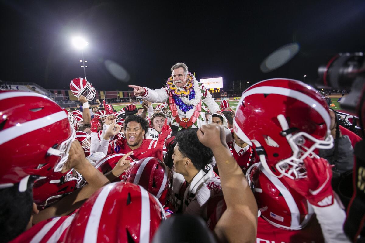 Mater Dei coach Bruce Rollinson is hoisted on the shoulders of his team after winning the CIF Open Division state title.