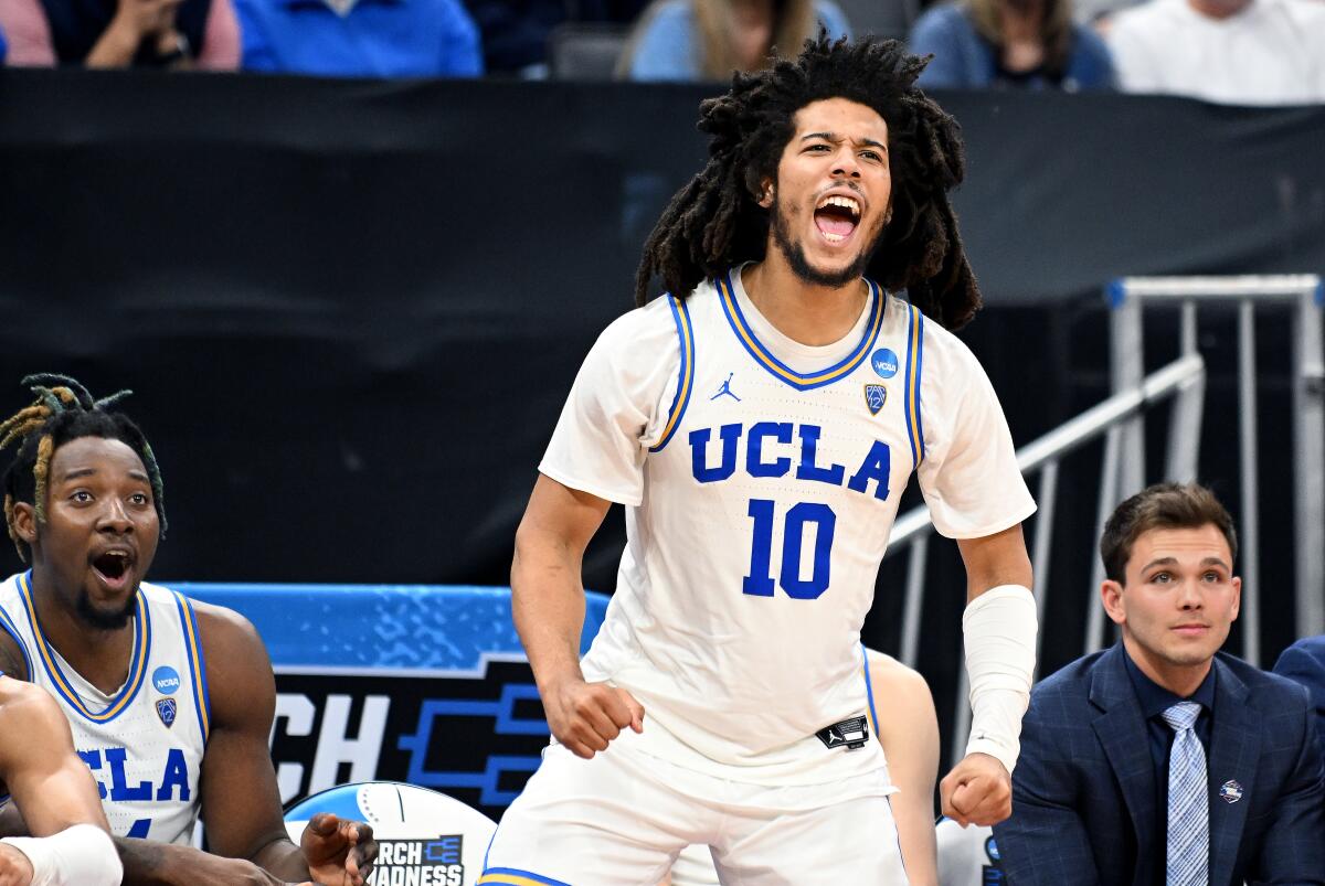 UCLA's Tyger Campbell stands on the sideline and celebrates the team's NCAA tournament win over UNC Asheville.