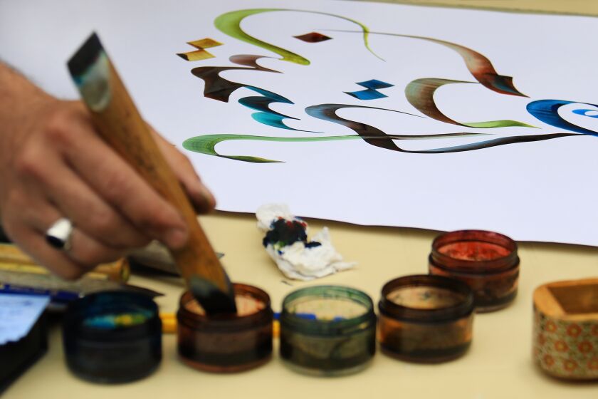A calligraphy artist works on Arabic writings.