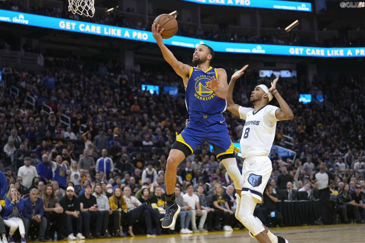 Golden State's Stephen Curry drives to the basket past Memphis' Ziaire Williams on May 13, 2022. 