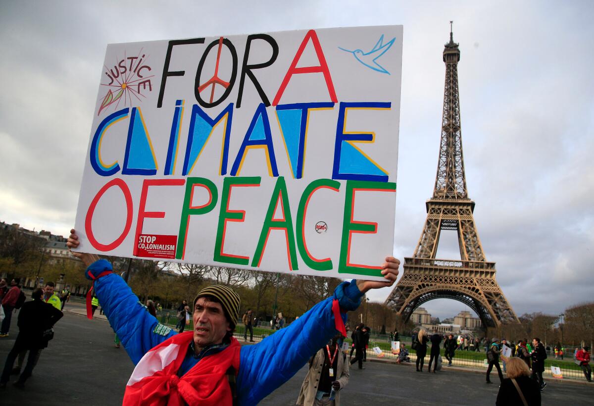 An activist holds a poster during a demonstration near the Eiffel Tower