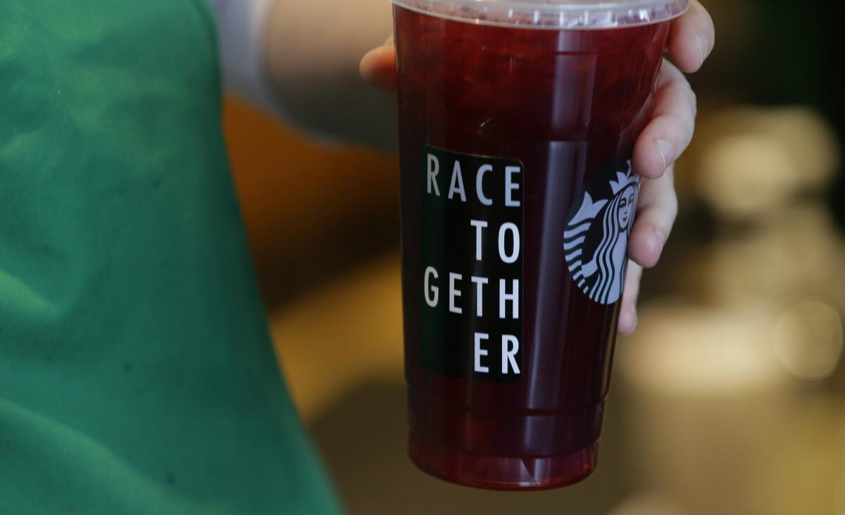 A barista holds a Starbucks iced tea drink with a "Race Together" sticker on it at a Starbucks store in Seattle on March 18.