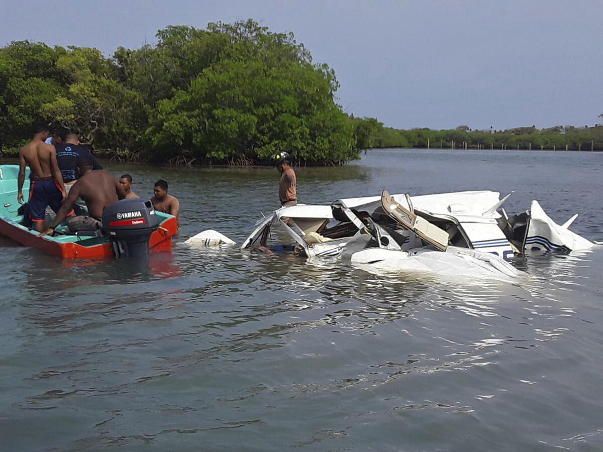 Esta foto proporcionada por el Departamento de Bomberos de Honduras muestra a rescatistas junto a una avioneta que cayó cerca de la isla de Roatán, en Honduras, el sábado 18 de mayo del 2019. (Departmento de Bomberos de Honduras vía AP)