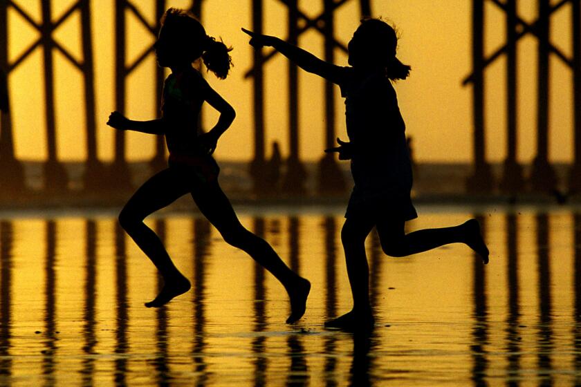 Rick Loomis   014664.ME.0826.beach.RLNewport BeachTwo kids run into the surf at Newport Beach recently. The Labor Day weekend symbolizies the end of summer for many.