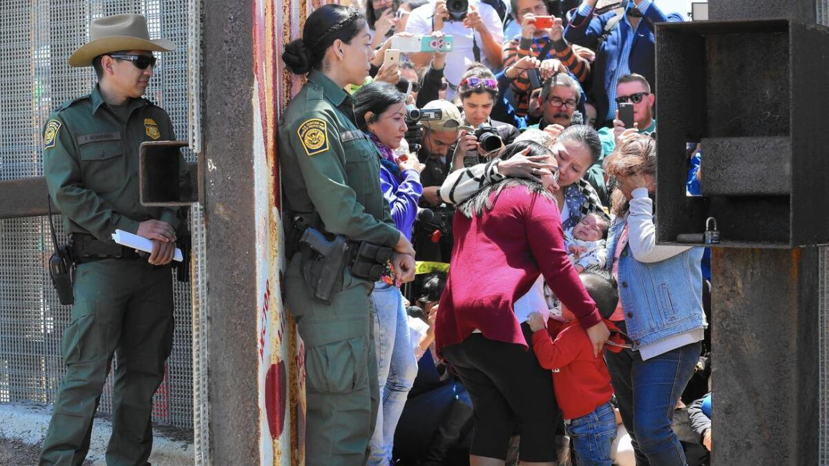 Agentes de la patrulla fronteriza observan a algunas familias que se reunieron brevemente cuando la Puerta de la Esperanza se abrió por algunos minutos en la frontera entre Tijuana y San Diego.