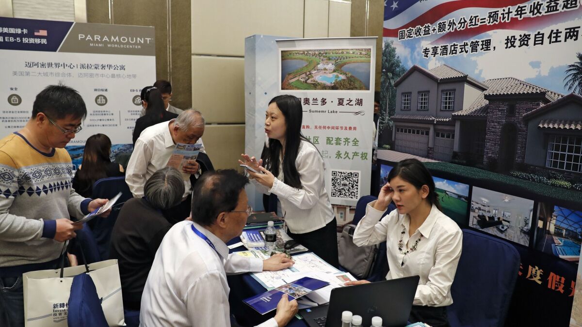 Chinese visitors seek information about the U.S. government's EB-5 visa program at an exhibitor booth in an Invest in America Summit in Beijing in 2017.