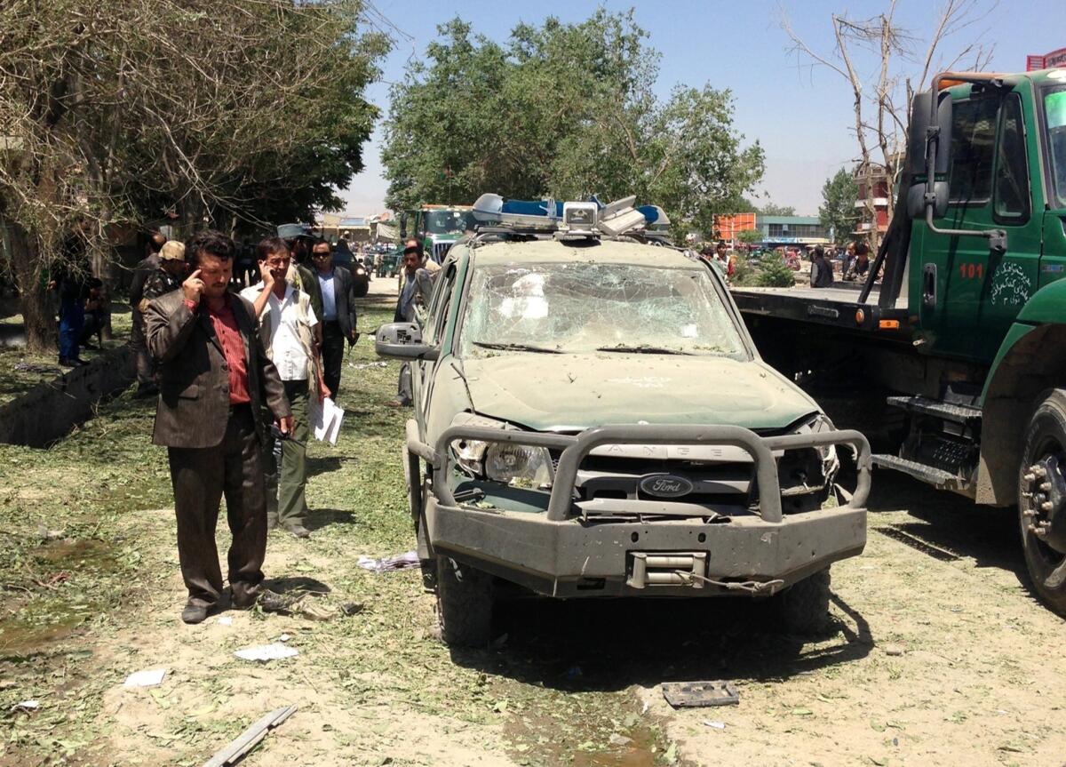 Afghanistan security forces stand guard at the site of a blast in western Kabul. The bombing occurred minutes before the formal hand-off of security responsibilities from NATO to Afghan forces.