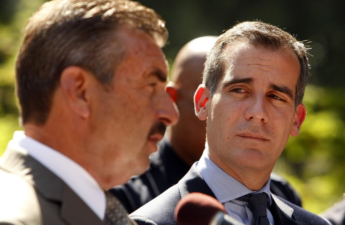 Los Angeles Mayor Eric Garcetti, right, and LAPD Chief Charlie Beck, left, make their announcement Monday at City Hall. They were cheered by immigration advocates.