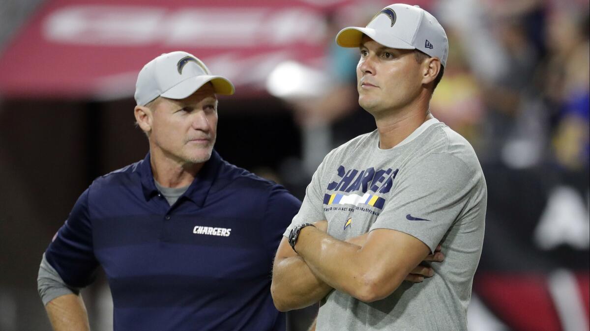 Chargers quarterback Philip Rivers, right, watches warm ups with assistant coach Ken Whisenhunt on Saturday night.