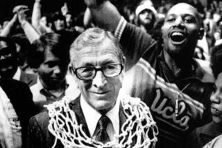 UCLA basketball coach John Wooden wears a basketball net around his neck after his team won the 1975 NCAA championship