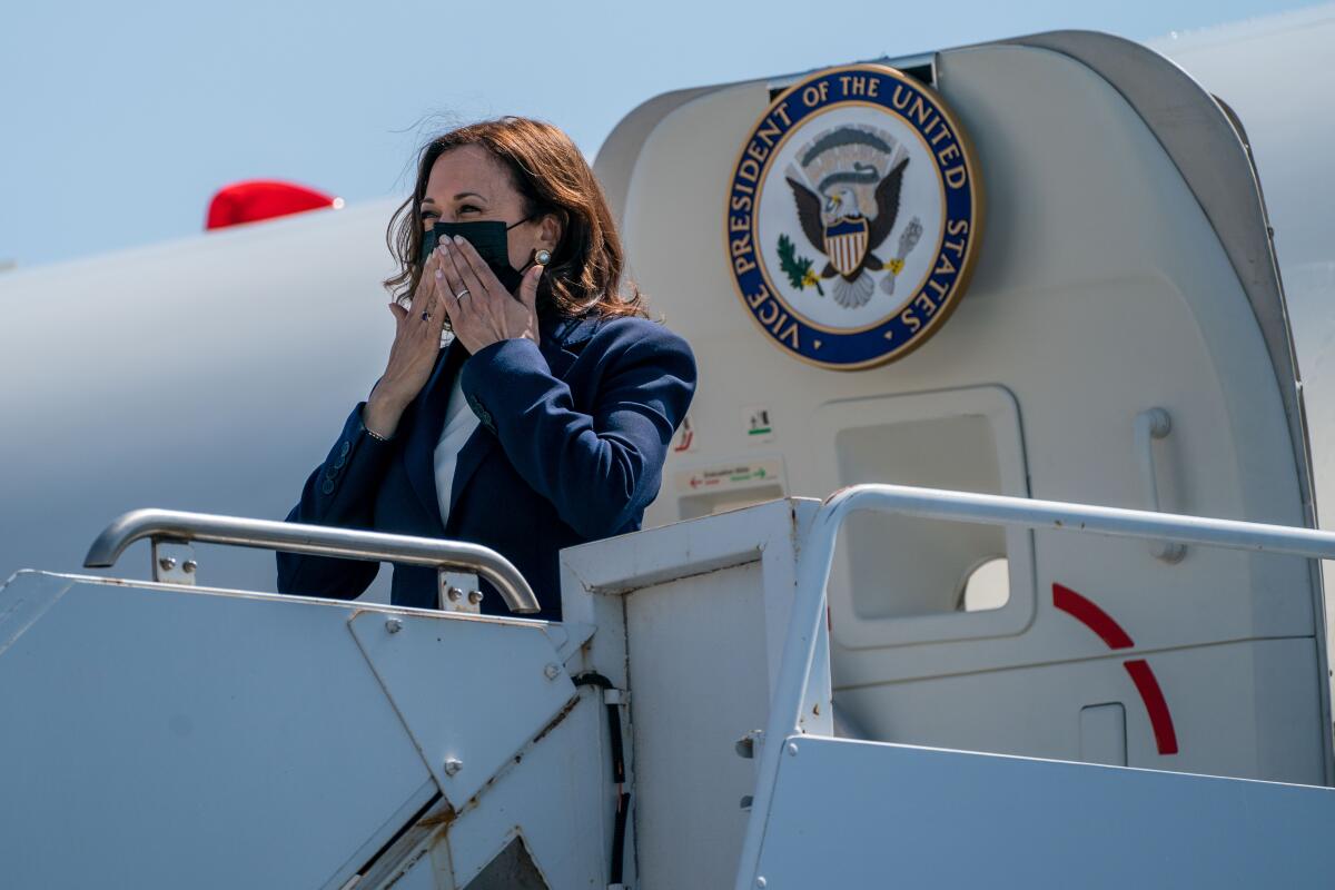Vice President Kamala Harris stands at the entrance to a plane