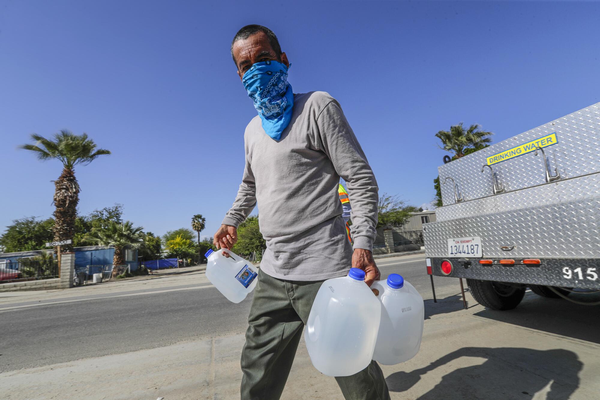 Jesus Ramon carries water bottles