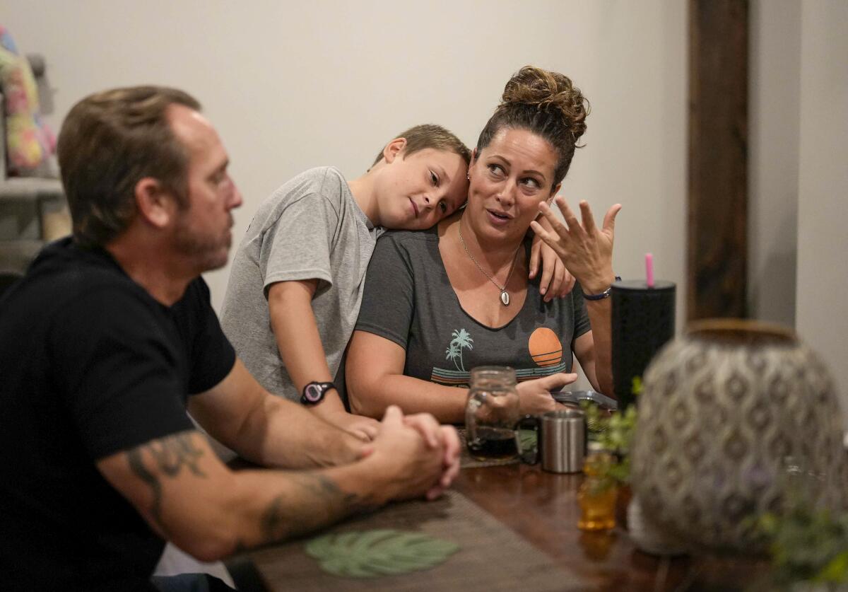 Christian O'Neil hugs his mother, Sara, during dinner at their home in Randall, Iowa.