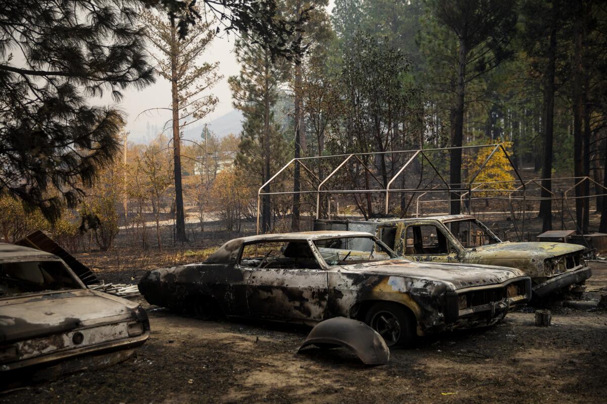 Cars destroyed by the Camp fire sit outside a home along Yana Trail. (Kent Nishimura / Los Angeles Times)