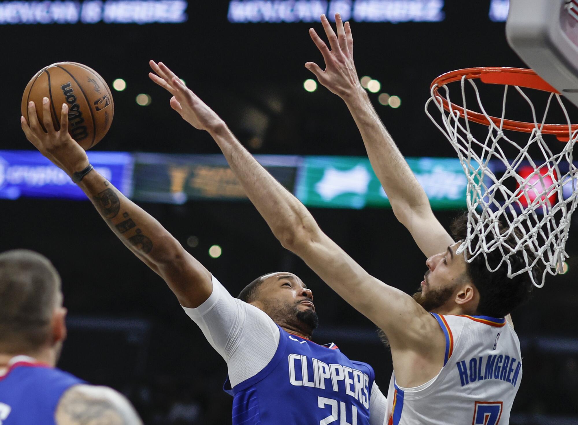 Clippers guardı Norman Powell (sağda), Thunder forveti Chet Holmgren'i geçerek turnikede gol atmaya çalışıyor.